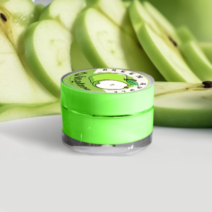 Barattolo di crema labbra Vitalzen al gusto di mela verde, circondato da fette di mela fresca, per labbra morbide e idratate con un tocco di freschezza
